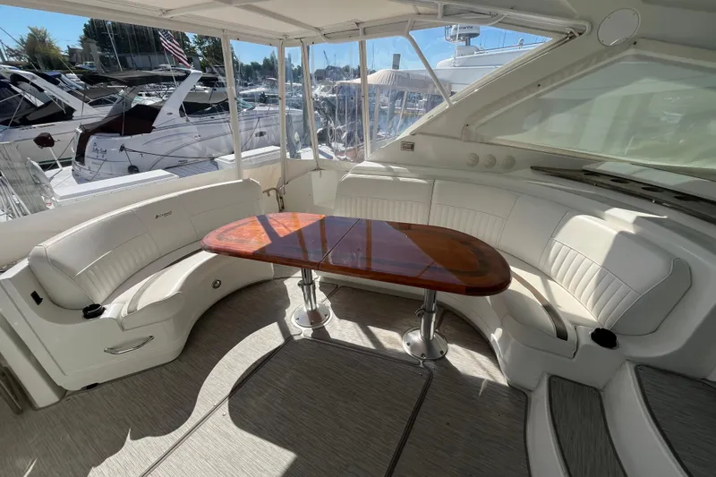 Slide: The Image of 2010 Cruisers Yachts 520 Sports Coupe interior with curved seating and wooden table. - 13