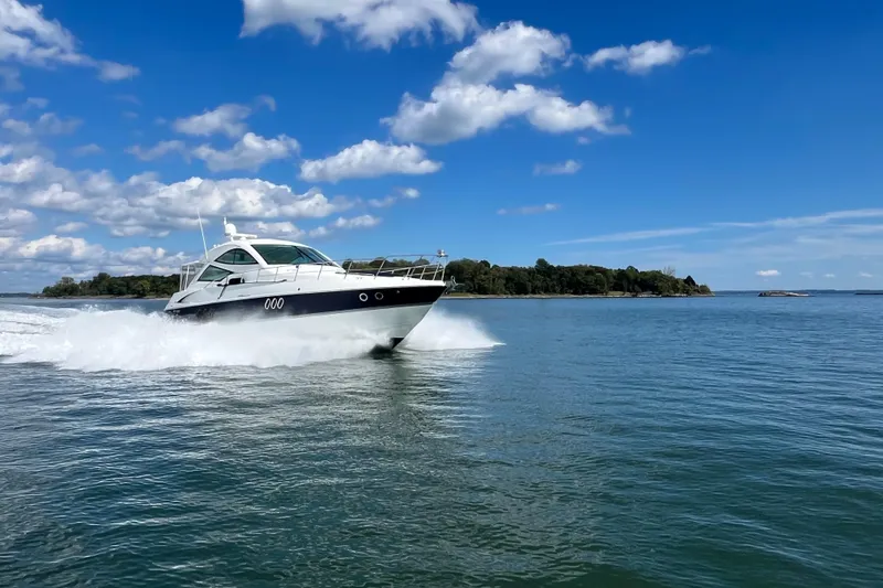 Slide: The Image of 2010 Cruisers Yachts 520 Sports Coupe on water, surrounded by other boats. - 8
