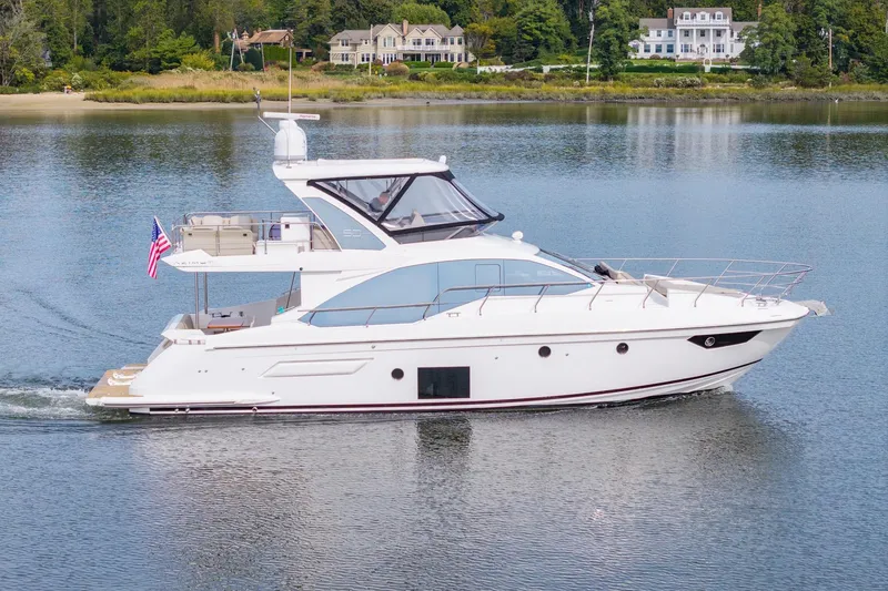 The Image of 2020 Azimut Fly 50 yacht cruising on a serene lake with luxury homes in the background. - 0