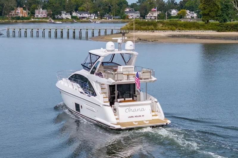 Slide: The Image of Azimut Fly 50 yacht cruising near shoreline, 2020 model, with American flag displayed. - 10