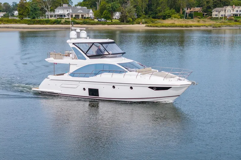 Slide: The Image of 2020 Azimut Fly 50 yacht cruising on calm waters near a scenic shoreline. - 4