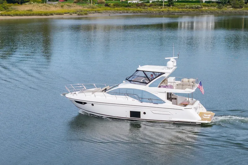 Slide: The Image of 2020 Azimut Fly 50 yacht cruising on a calm lake with lush greenery. - 6