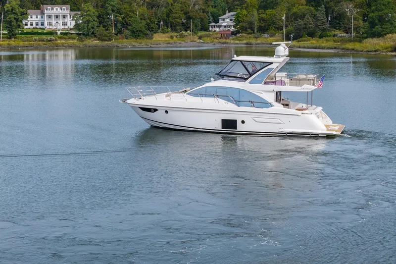 Slide: The Image of 2020 Azimut Fly 50 yacht cruising on a serene lake with lush greenery. - 9