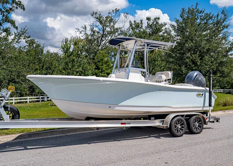 The Image of 2026 Sea Hunt Ultra 219 boat on trailer, parked outdoors under a blue sky. - 1