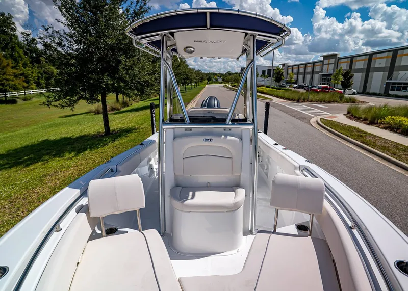 Slide: The Image of 2026 Sea Hunt Ultra 219 boat interior with seating, parked on a scenic road. - 19