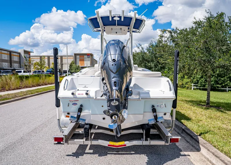 Slide: The Image of 2026 Sea Hunt Ultra 219 boat on trailer, parked on sunny street. - 3