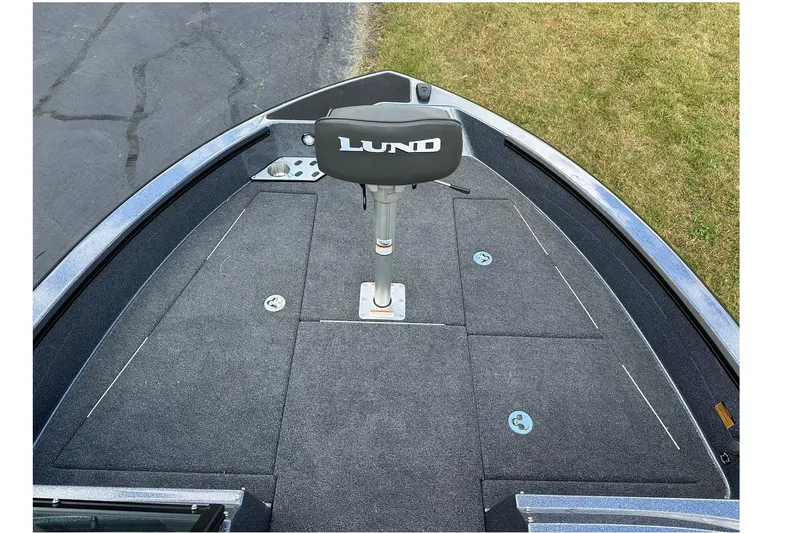 Slide: The Image of 2026 Lund 189 Pro-V GL boat deck with seat, gray carpet, and storage compartments. - 12