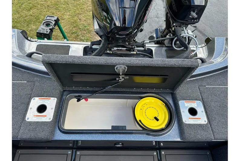 Slide: The Image of 2026 Lund 189 Pro-V GL boat storage compartment with open lid and visible engine. - 9