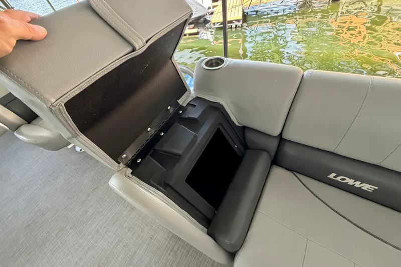 Slide: The Image of 2021 Lowe SS 270 boat seat storage compartment with cup holder, open on a sunny day. - 15