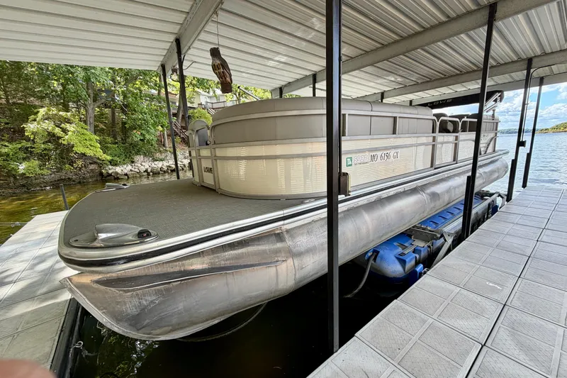 Slide: The Image of 2021 Lowe SS 270 Extended WT pontoon boat docked under a covered structure. - 2