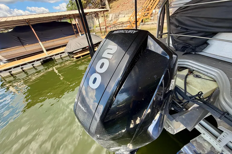 Slide: The Image of Outboard motor on a 2021 Lowe SS 270 Extended WT boat docked by the water. - 29
