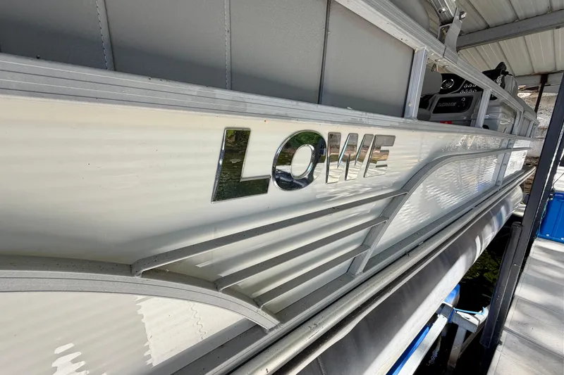 Slide: The Image of 2021 Lowe SS 270 Extended WT pontoon boat docked under shelter. - 3