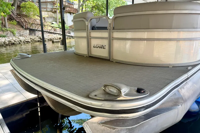 Slide: The Image of 2021 Lowe SS 270 Extended WT pontoon boat docked by a lakeside. - 6
