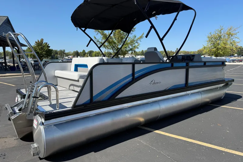 Slide: The Image of 2026 Qwest E-Class 22 Lanai pontoon boat with canopy, parked on asphalt. - 4