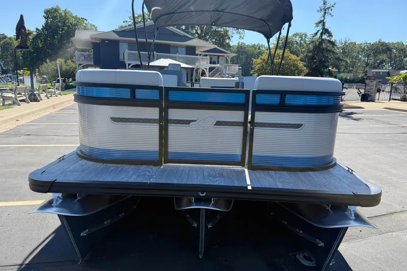 Slide: The Image of 2026 Qwest E-Class 22 Lanai pontoon boat parked on pavement. - 5