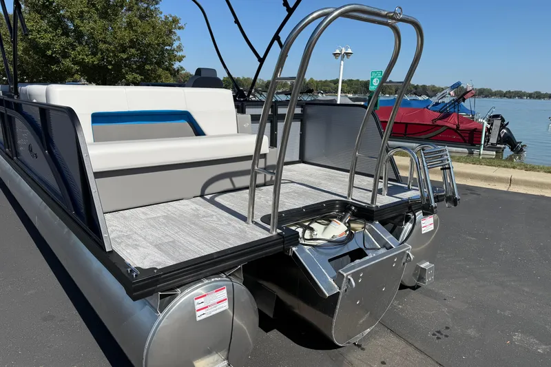 Slide: The Image of 2026 Qwest E-Class 22 Lanai pontoon boat with seating, docked by a lake. - 7