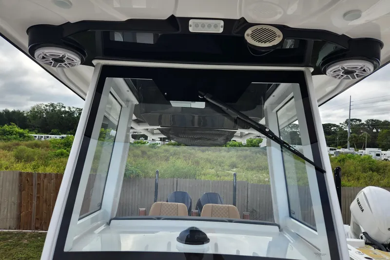 Slide: The Image of 2026 Caymas 291 boat windshield and speakers, outdoor setting with greenery. - 10