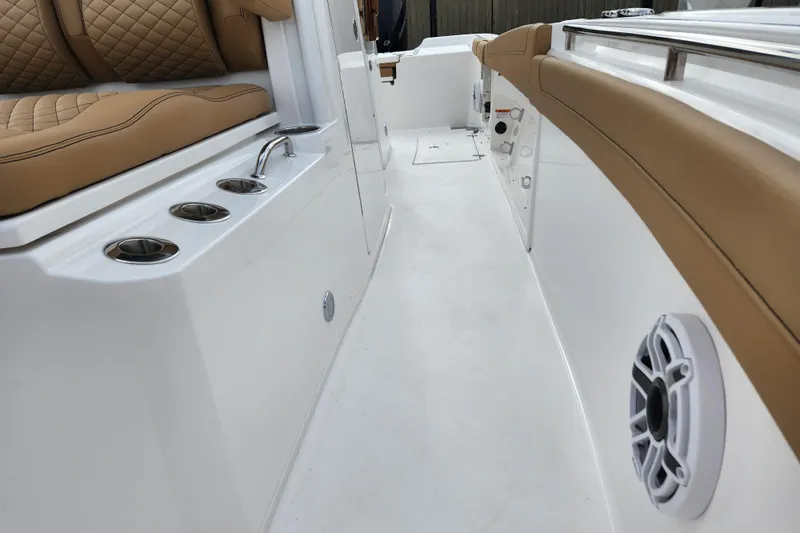 Slide: The Image of 2026 Caymas 291 boat interior with tan seating, cup holders, and speaker. - 13