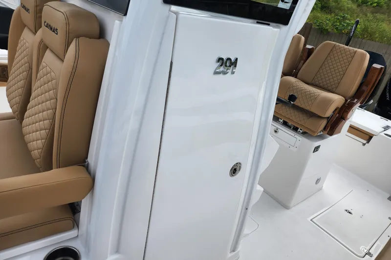 Slide: The Image of 2026 Caymas 291 boat interior with tan quilted seats and sleek white design. - 15