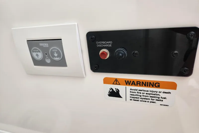 Slide: The Image of Control panel and warning label on 2026 Caymas 291 boat, featuring overboard discharge. - 18