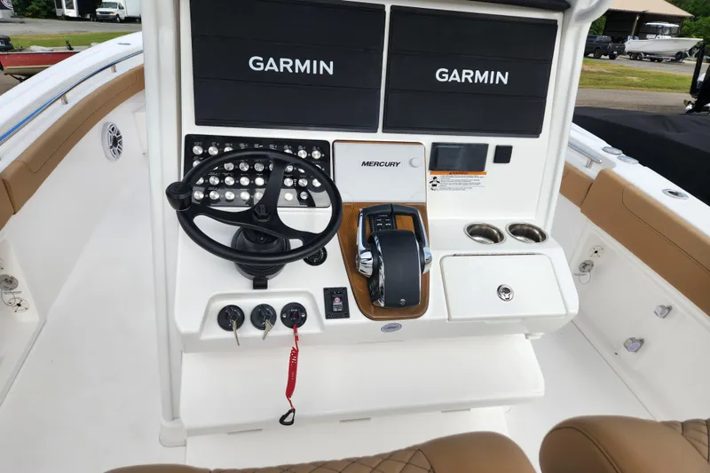 Slide: The Image of 2026 Caymas 291 boat dashboard with Garmin displays and Mercury controls. - 25
