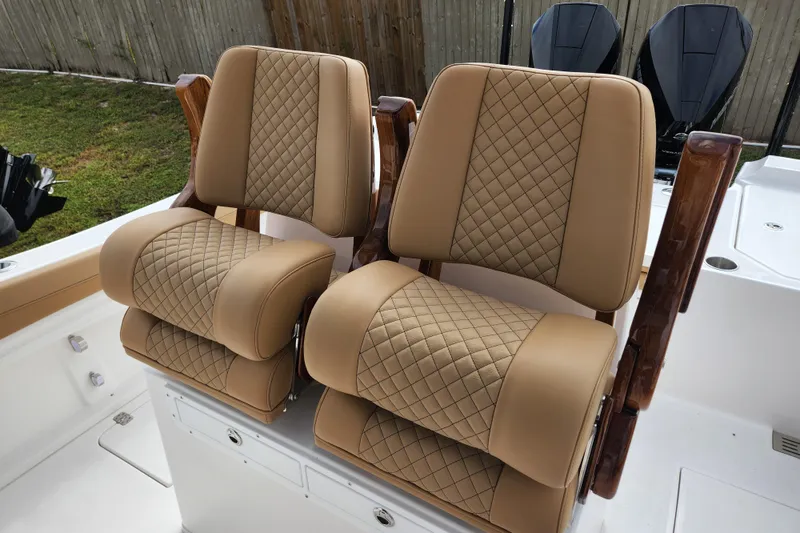 Slide: The Image of Luxurious tan leather seats on 2026 Caymas 291 boat, featuring diamond stitching and wooden armrests. - 27