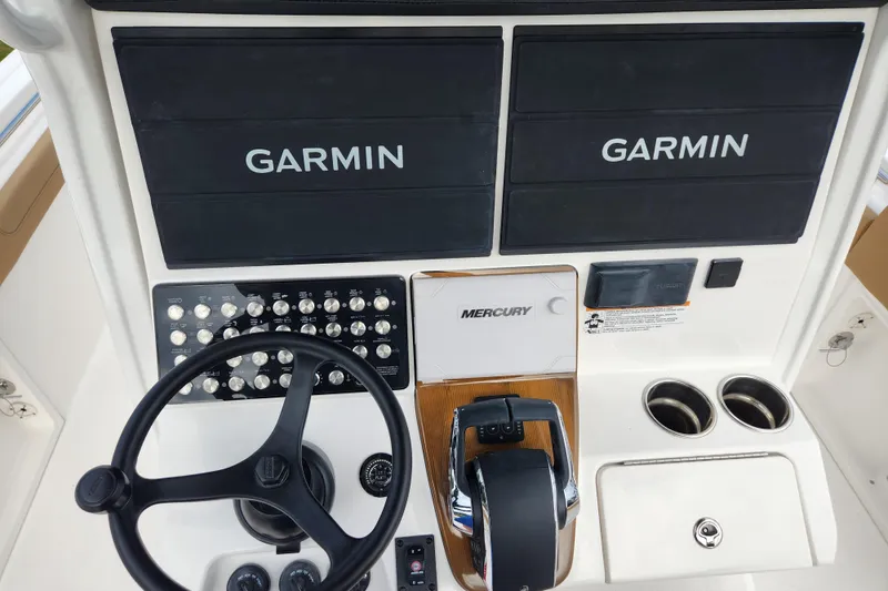 Slide: The Image of 2026 Caymas 291 boat dashboard with Garmin displays and Mercury controls. - 29