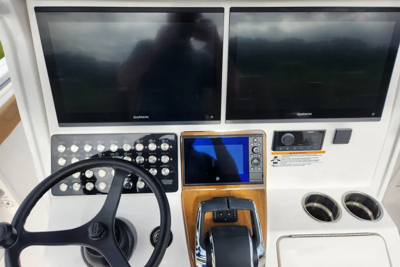 Slide: The Image of 2026 Caymas 291 boat dashboard with dual Garmin screens and control panel. - 32