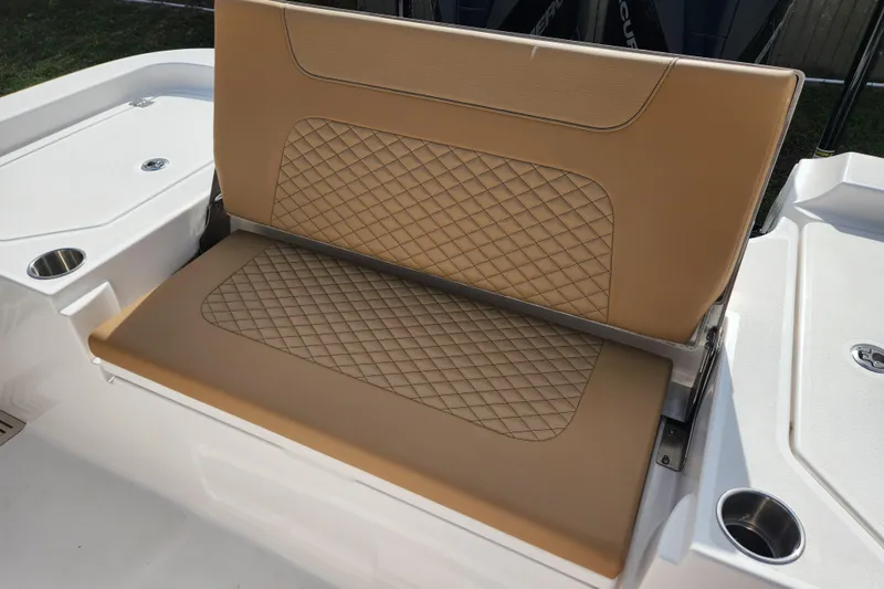 Slide: The Image of 2026 Caymas 291 boat seat with tan diamond-stitched upholstery and integrated cup holders. - 43