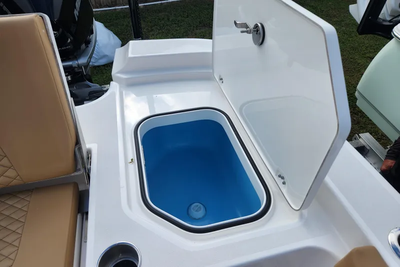 Slide: The Image of 2026 Caymas 291 boat with open storage compartment and tan seating. - 44