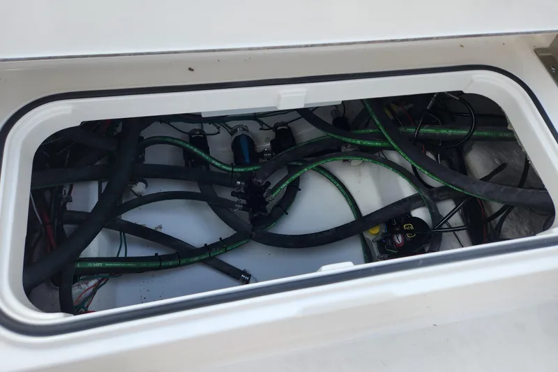 Slide: The Image of Open compartment of 2026 Caymas 291 boat showing internal wiring and hoses. - 46