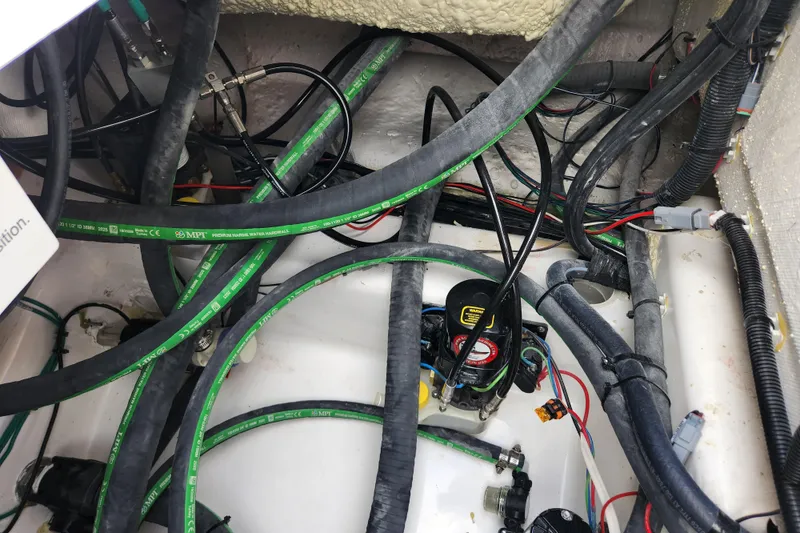 Slide: The Image of Engine compartment of 2026 Caymas 291 boat with visible wiring and hoses. - 48