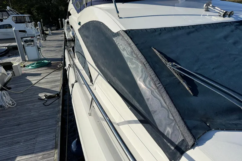 Slide: The Image of 2008 Sunseeker Manhattan 50 yacht docked, showcasing sleek design and covered windows. - 15