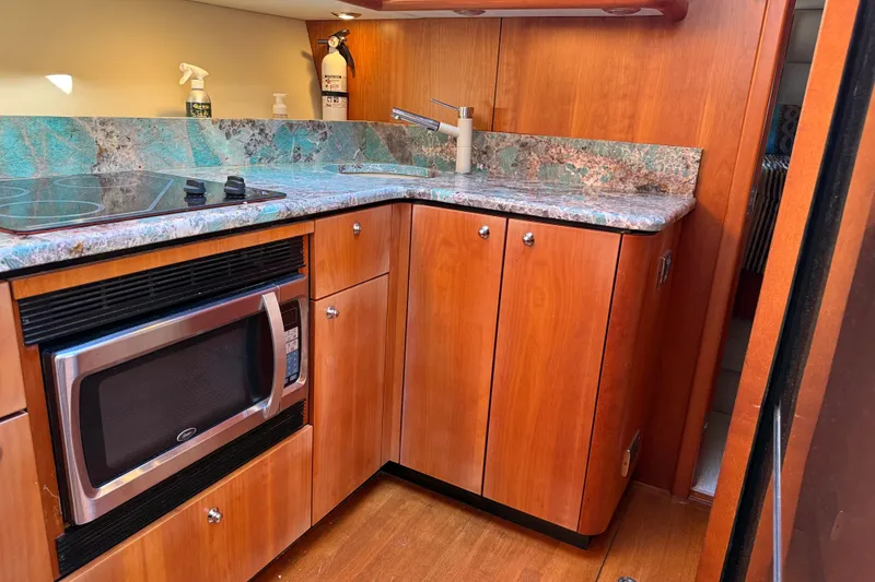 Slide: The Image of Luxurious 2008 Sunseeker Manhattan 50 yacht kitchen with wood cabinetry and modern appliances. - 54