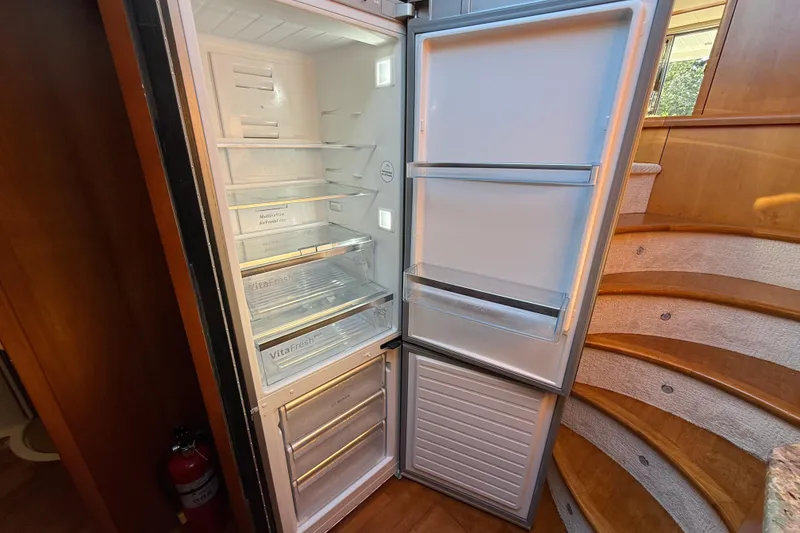 Slide: The Image of Open refrigerator inside 2008 Sunseeker Manhattan 50 yacht, near wooden staircase. - 57