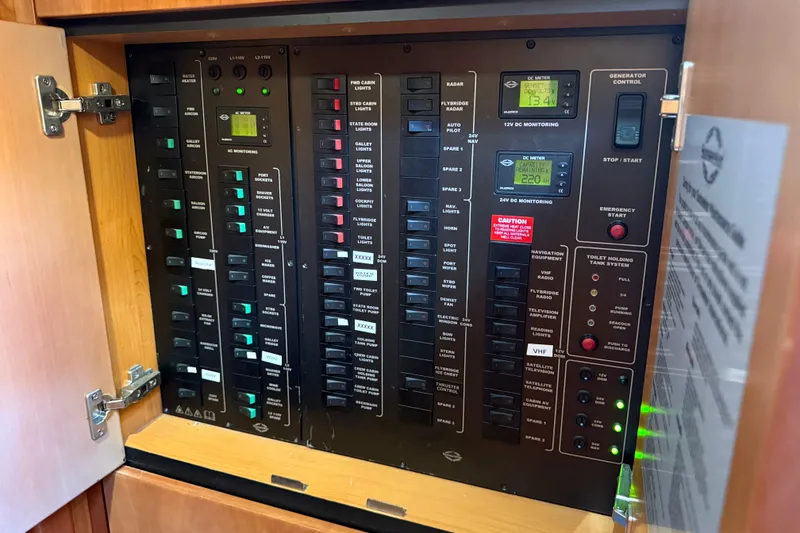 Slide: The Image of Electrical control panel inside a 2008 Sunseeker Manhattan 50 yacht, featuring various switches and meters. - 69