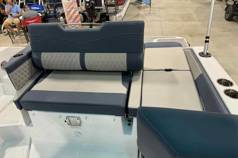 Slide: The Image of 2026 Monterey Elite 27 SD boat seating with blue and gray upholstery at a showroom. - 17
