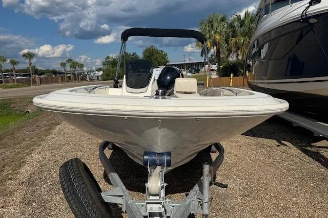 Slide: The Image of 2022 Boston Whaler 160 Super Sport boat on trailer, parked outdoors under cloudy sky. - 10