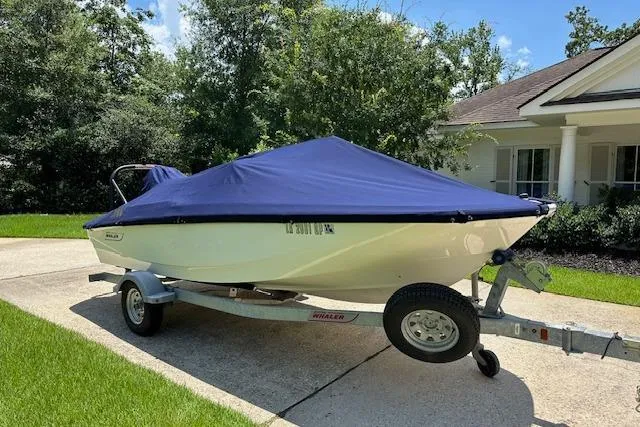 Slide: The Image of 2022 Boston Whaler 160 Super Sport boat on trailer, covered, parked in driveway. - 11