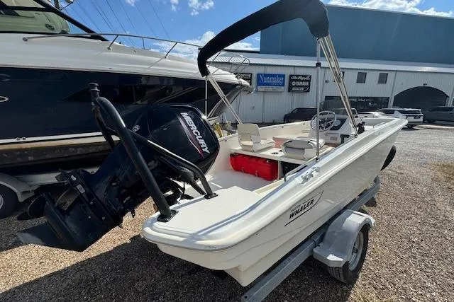 Slide: The Image of 2022 Boston Whaler 160 Super Sport boat with Mercury engine on trailer, outdoor setting. - 13