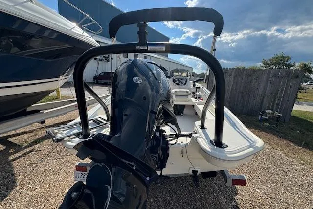 Slide: The Image of 2022 Boston Whaler 160 Super Sport boat with outboard motor, parked outdoors. - 14