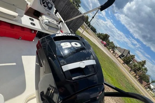 Slide: The Image of 2022 Boston Whaler 160 Super Sport with Mercury 90 engine, parked outdoors under a cloudy sky. - 15