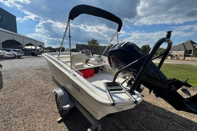 Slide: The Image of 2022 Boston Whaler 160 Super Sport boat on trailer, outdoor setting, partly cloudy sky. - 16