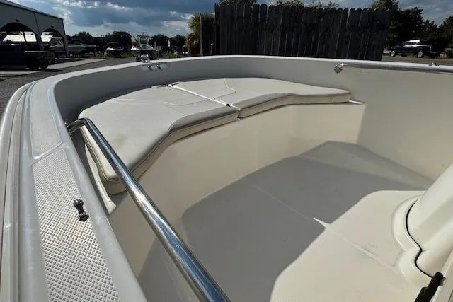 Slide: The Image of 2022 Boston Whaler 160 Super Sport boat interior with cushioned seating and railing. - 18