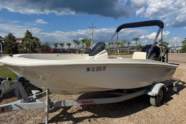 Slide: The Image of 2022 Boston Whaler 160 Super Sport boat on trailer, parked outdoors under a cloudy sky. - 3
