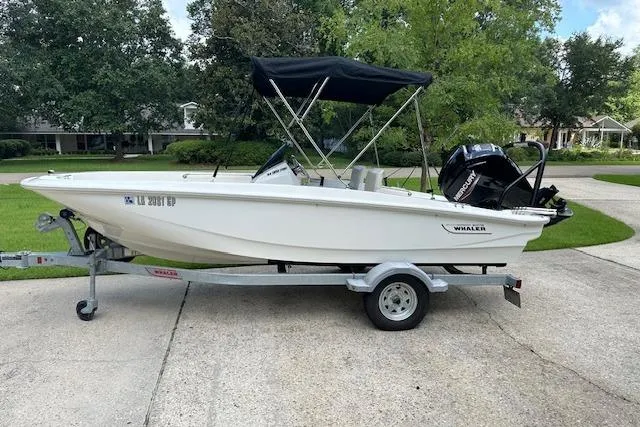 Slide: The Image of 2022 Boston Whaler 160 Super Sport boat on trailer, parked in a residential driveway. - 8