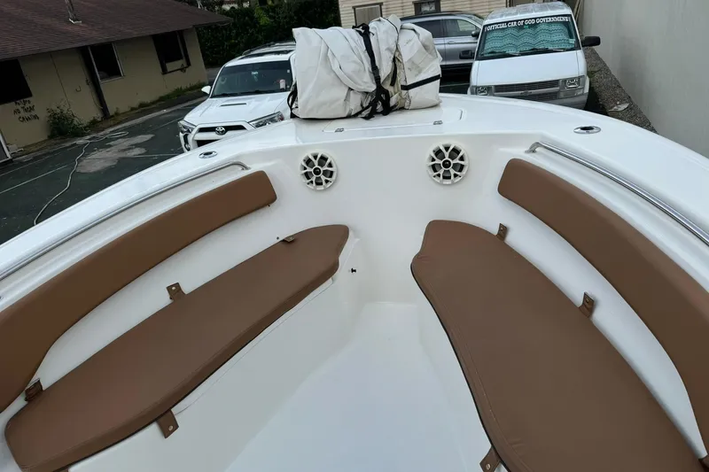 Slide: The Image of 2017 Tidewater 220 CC Adventure boat interior with brown seating and white speakers. - 8