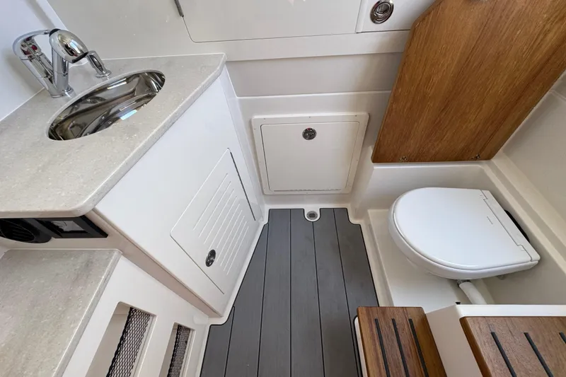 Slide: The Image of 2026 Sailfish 360 CC boat bathroom with sink, toilet, and wooden accents. - 20