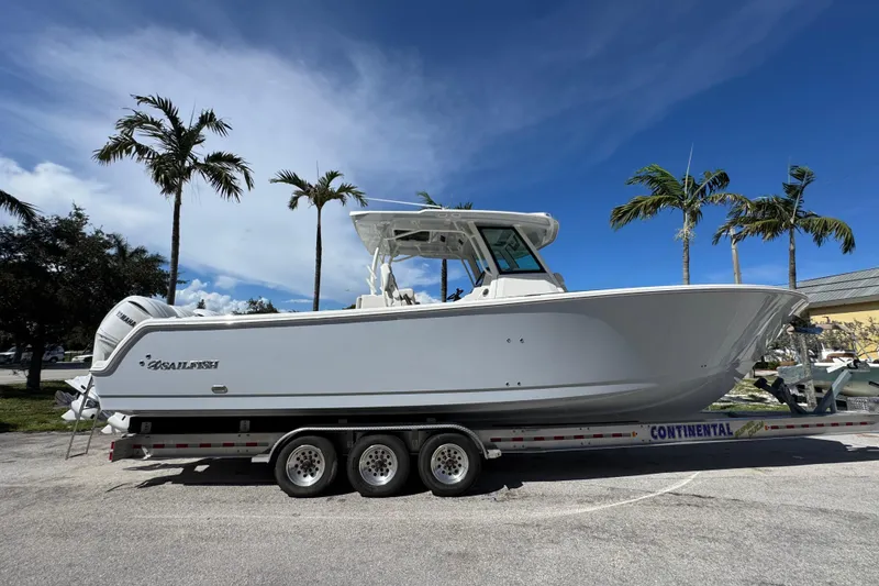Slide: The Image of 2026 Sailfish 360 CC boat on trailer, parked under palm trees, clear blue sky. - 3