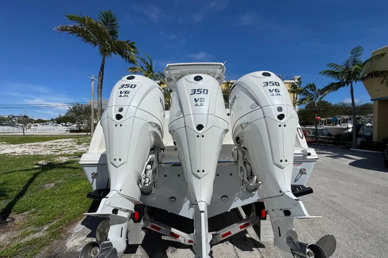 Slide: The Image of 2026 Sailfish 360 CC boat with triple 350 V6 engines, parked outdoors. - 8